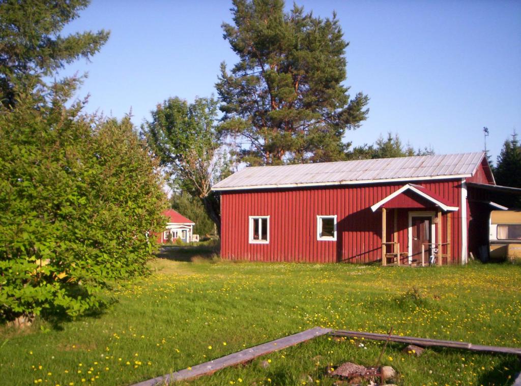 een rode schuur midden in een veld bij Christinagårdens stuga in Ramsele
