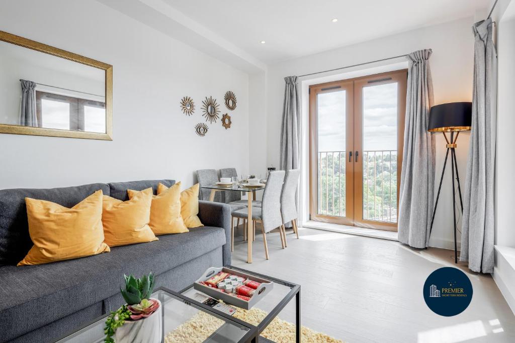 a living room with a gray couch and a table at Heliodoor Apartments St Albans City GREAT LOCATION Direct trains to London St Pancras 18 mins, Gatwick & Luton Airports in St. Albans