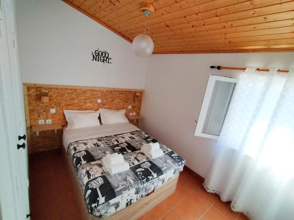 a bedroom with a bed in a room with a window at SigmaApartment in Zambujeira do Mar