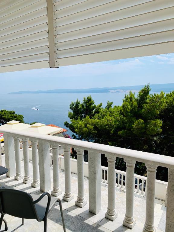 a white balcony with a view of the ocean at Villa Raljević in Stanići