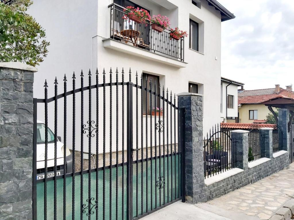 a black metal fence with a white house at Sharkova House Bansko in Bansko