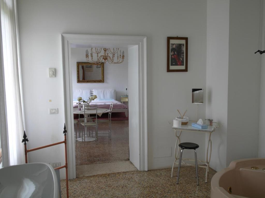 una camera con una camera da letto con un tavolo e un letto di B&B Giardino Jappelli (Villa Ca' Minotto) a Rosà