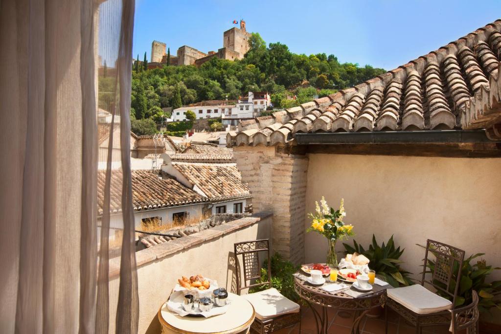 balcón con mesas y vistas a un castillo en Hotel Casa 1800 Granada en Granada