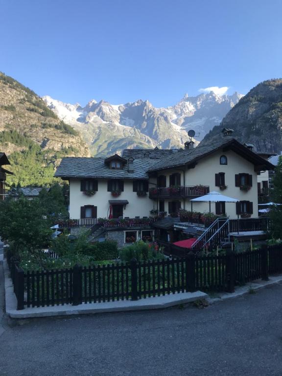 a house with a fence in front of a mountain at Maison Laurent in Courmayeur