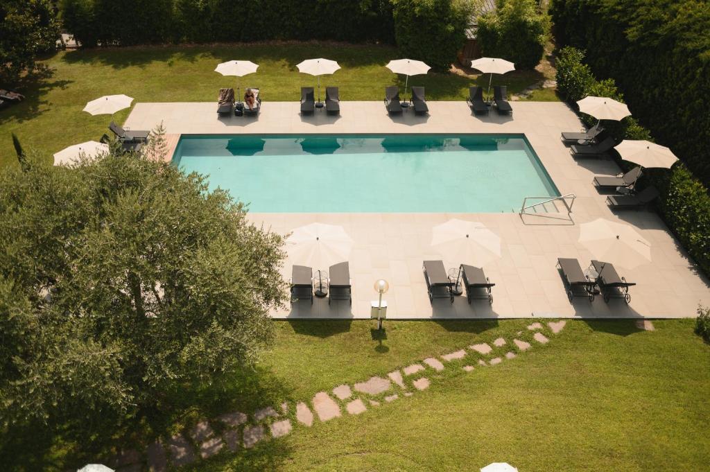 uma vista superior para uma piscina com cadeiras e guarda-sóis em Hotel Pollinger em Merano