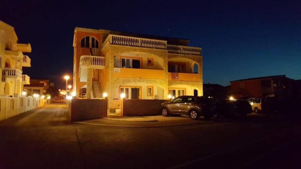 ein Gebäude mit nachts vor ihm geparkt in der Unterkunft Apartmani Por in Vir