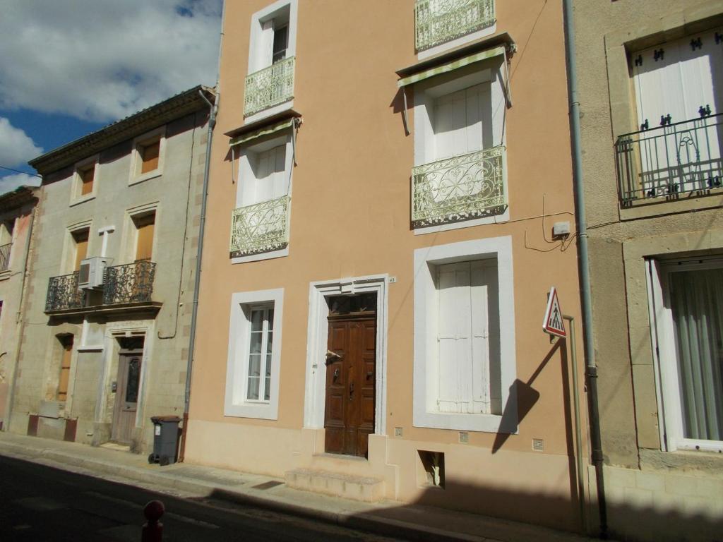 un edificio con una puerta marrón y ventanas en una calle en Magalas Retreat, en Magalas