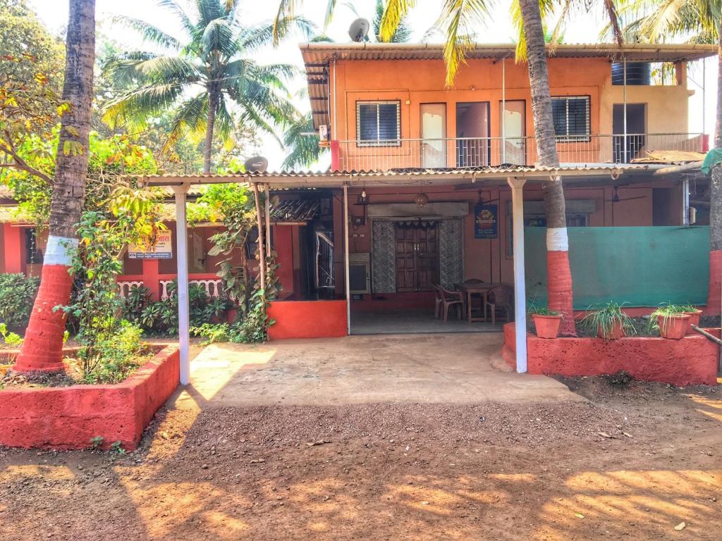 a house with palm trees in front of it at Aviraj Nivas in Dapoli