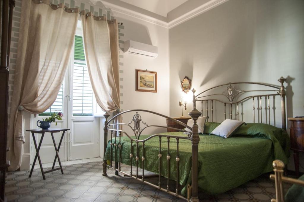 a bedroom with a green bed and a window at Amaranta in Palermo