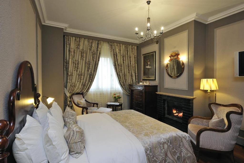 a hotel room with a bed and a fireplace at Hôtel de la Cigogne in Geneva