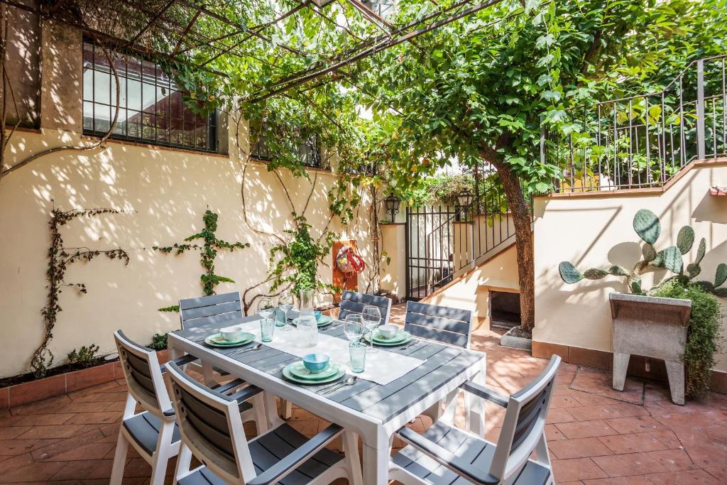 een tafel en stoelen op een patio met bomen bij Santa Reparata Apartment with Patio and Terrace in Florence