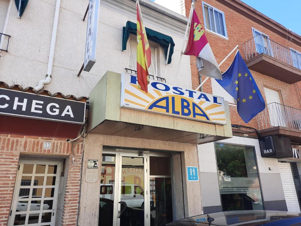 um sinal para um restaurante com bandeiras em frente em Hostal Alba em Albacete