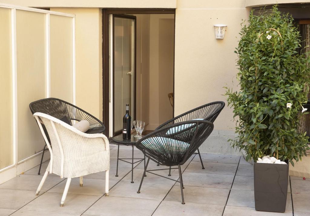 3 Stühle und ein Tisch auf einer Terrasse in der Unterkunft Aletxo's Home in San Sebastián