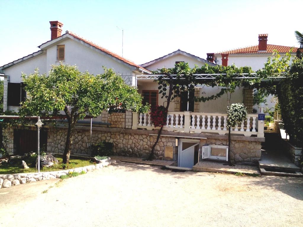 a house with a white fence and a driveway at Apartment Marija in Krk