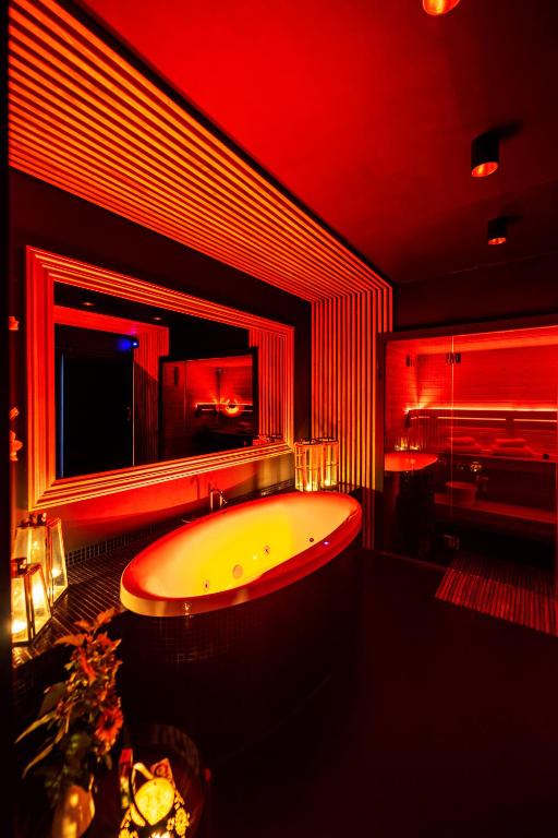 a bathroom with a tub with a mirror and a piano at Spa Love Apartament Sauna Jacuzzi ROMANTYCZNY APARTAMENT DLA PARY Z PRYWATNYM SPA in Zielona Góra