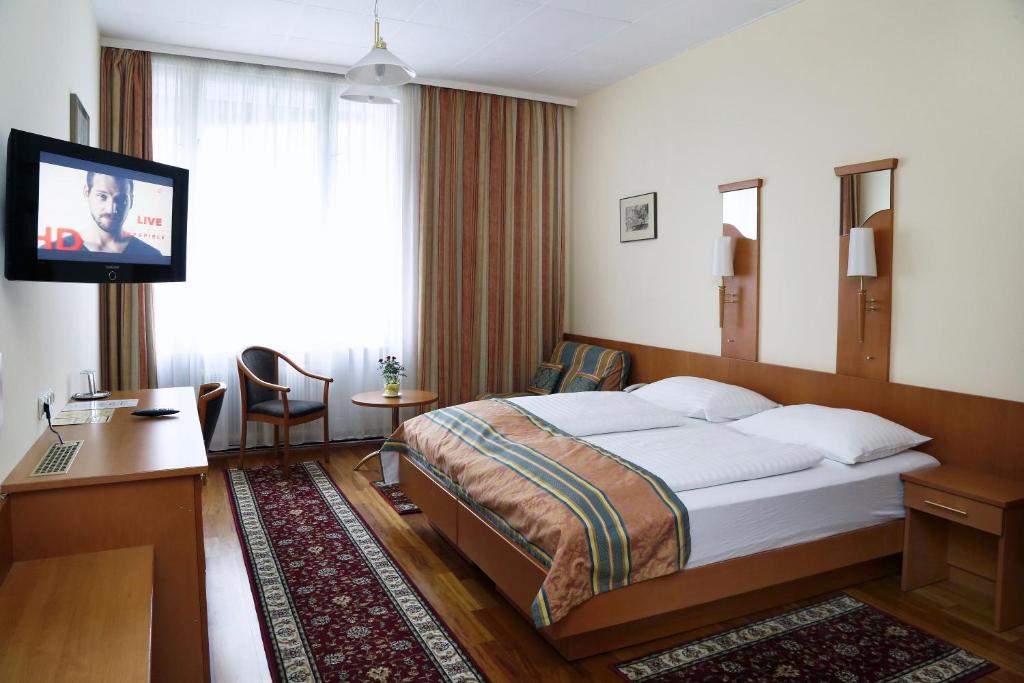 Habitación de hotel con cama y TV de pantalla plana. en Continental Hotel-Pension, en Viena