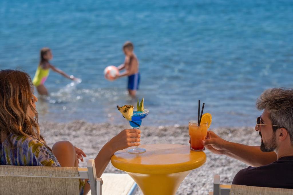 a group of people sitting at a table on the beach at Poseidon The Beach Hotel in Budva