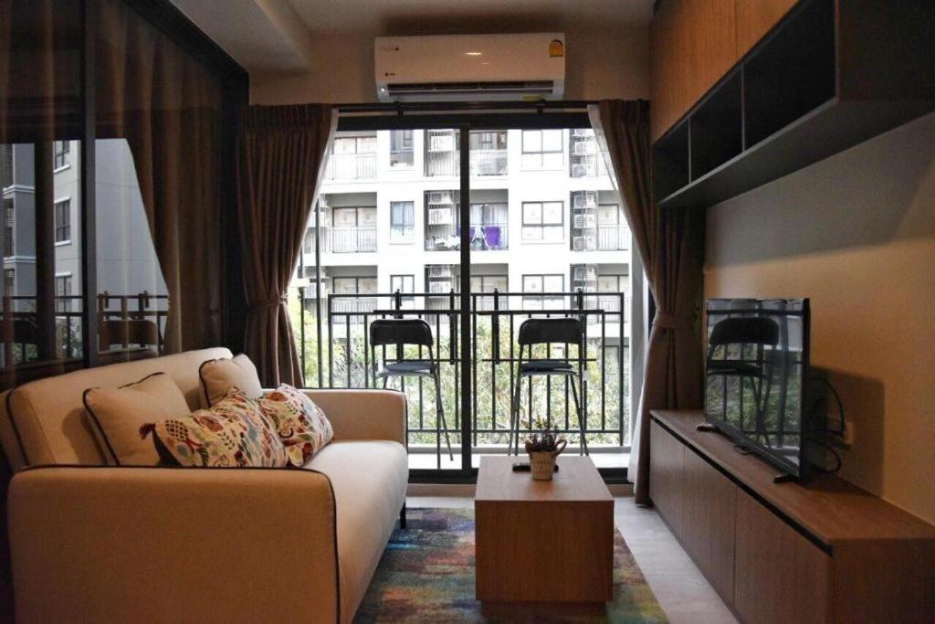 ein Wohnzimmer mit einem Sofa und einem großen Fenster in der Unterkunft La Casita Hua Hin By Takky in Hua Hin