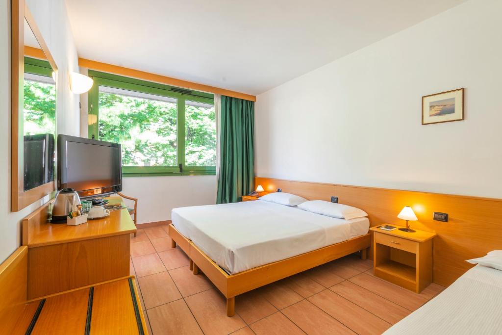 een hotelkamer met een bed en een flatscreen-tv bij Park Hotel Abbadia in Abbadia Lariana