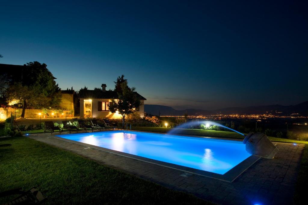 a swimming pool in the yard of a house at night at Agriturismo il Girasole in Montefalco