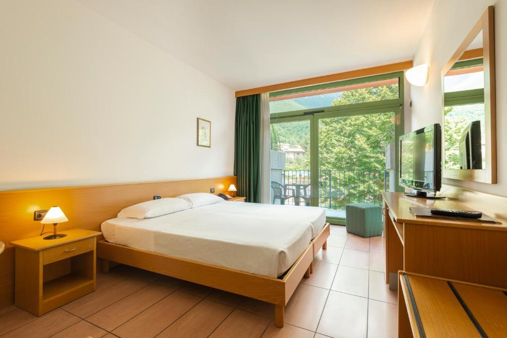 een hotelkamer met een bed en een televisie bij Park Hotel Abbadia in Abbadia Lariana