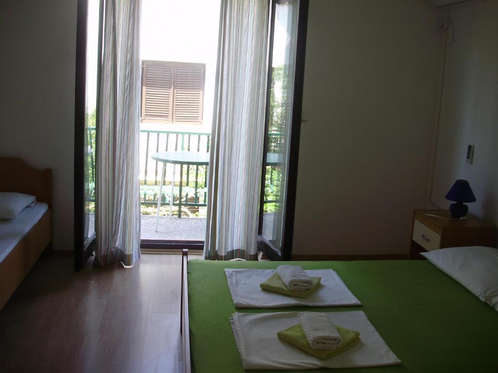 a bedroom with two beds and a large window at Villa Welcome in Vrboska