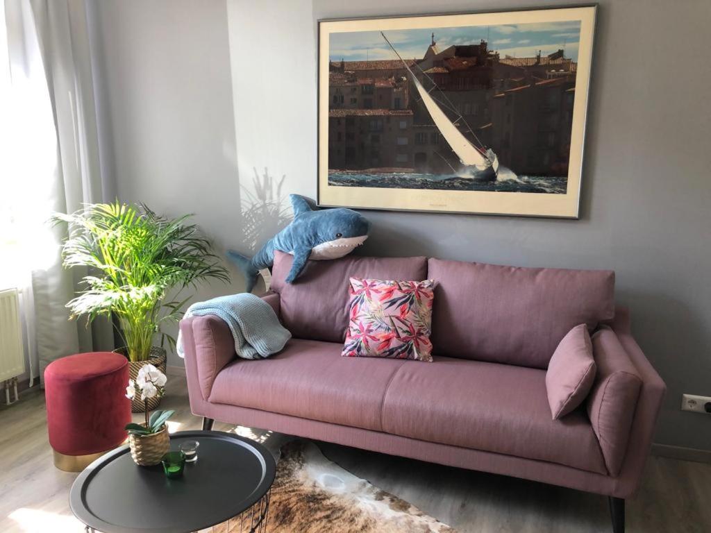 un sofá púrpura en una sala de estar con un animal de peluche en Fewo Seemöwe, en Bremerhaven
