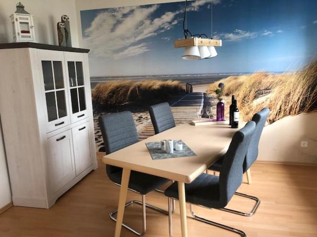 道努姆的住宿－Bi Grete tohuus，用餐室配有带绘画的桌椅