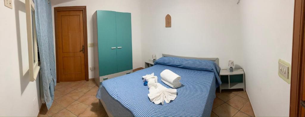 Un dormitorio con una cama azul con toallas. en La Casa di Alessio, en Tropea