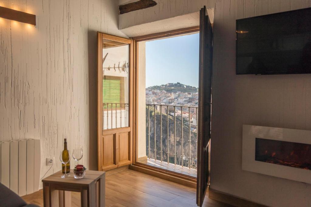 een woonkamer met een groot raam met uitzicht bij Alojamiento Turístico Alfonso y Catalina in Cuenca