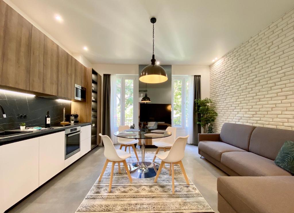 uma cozinha e sala de estar com um sofá e uma mesa em Maxim - Easy Home Booking em Nice