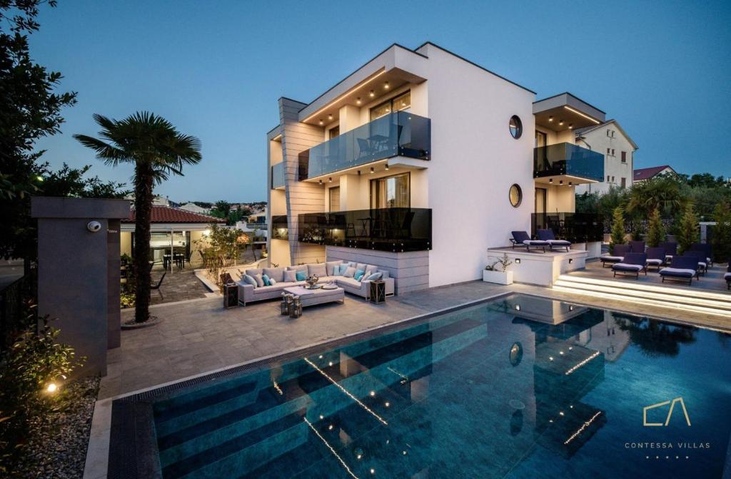 a house with a swimming pool in front of it at Luxury Apartments in Villa Curiera in Malinska