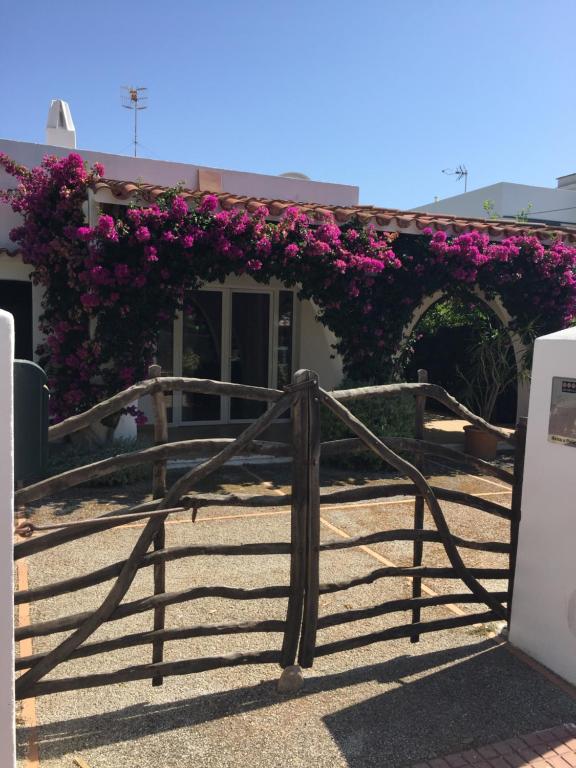 a gate with purple flowers on a building at Chalet tranquilo y acogedor a 50 metros de la playa in Cala Blanca