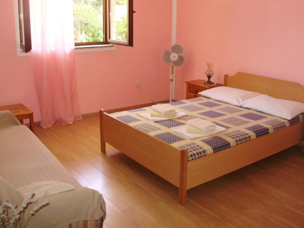 a bedroom with a bed and a fan at Villa Welcome in Vrboska