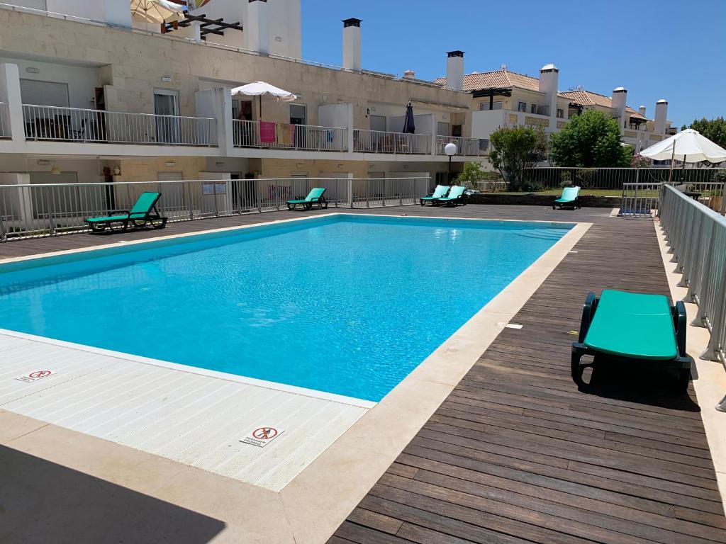 a swimming pool in front of a building at Penthouse Ria in Santa Luzia