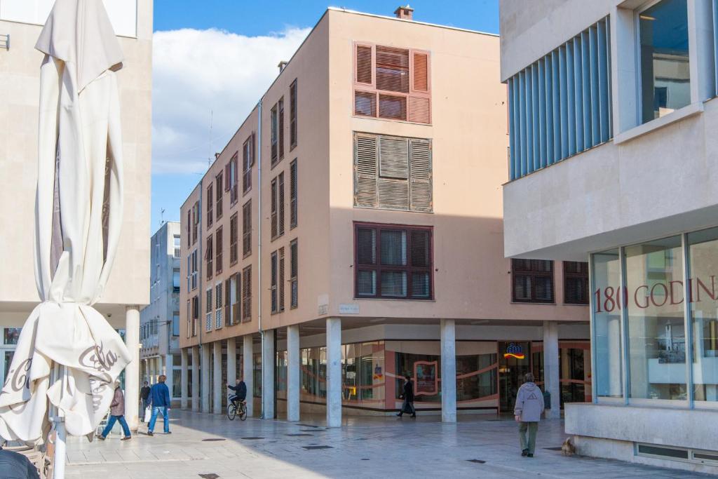 un edificio con gente caminando delante de él en Downtown Zadar Apartments, en Zadar