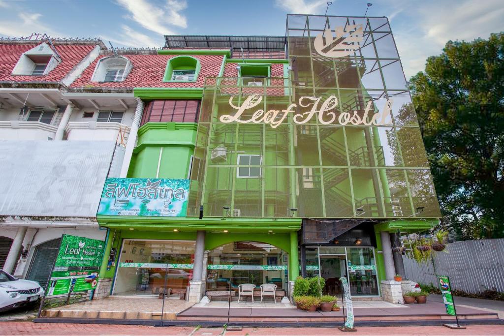 a large green building with a sign on it at OYO 928 Leaf Hostel in Chiang Mai