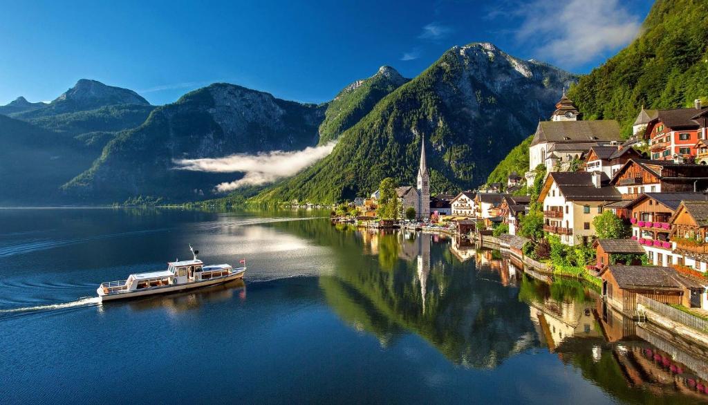 una pequeña ciudad en un río con montañas en Haus am Hof - 15th century house at the lake, near the marketplace, with a balcony en Hallstatt