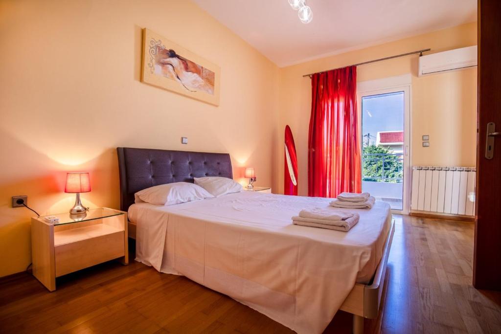 sypialnia z dużym łóżkiem z czerwoną zasłoną w obiekcie Rose Garden House w mieście Kremasti