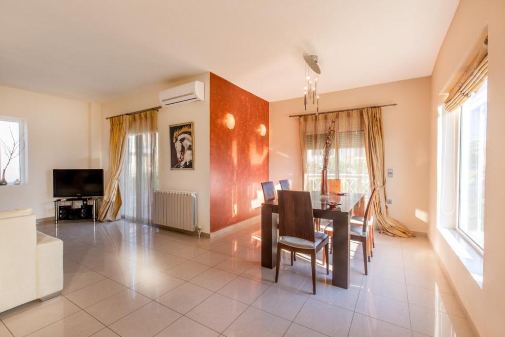 jadalnia ze stołem i krzesłami w obiekcie Rose Garden House w mieście Kremasti