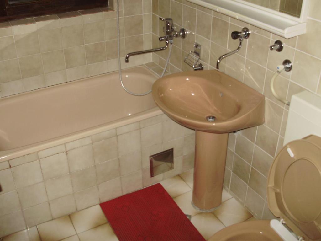 a bathroom with a sink and a toilet and a tub at Villa Welcome in Vrboska