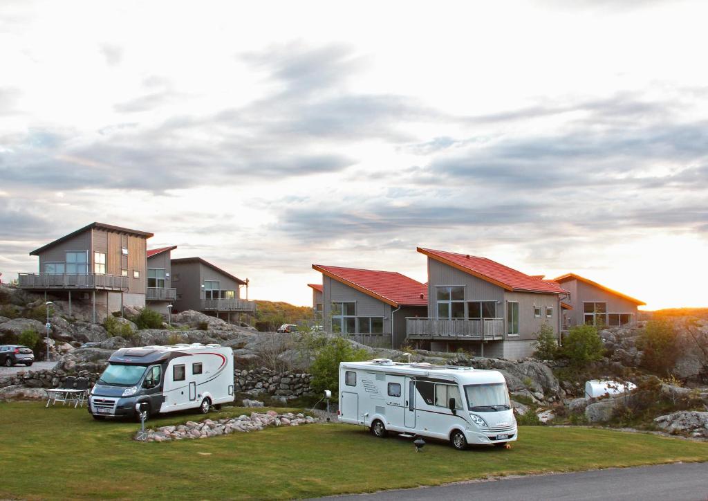 dos caravanas estacionadas en un patio frente a las casas en Hav & Logi Skärhamn en Skärhamn