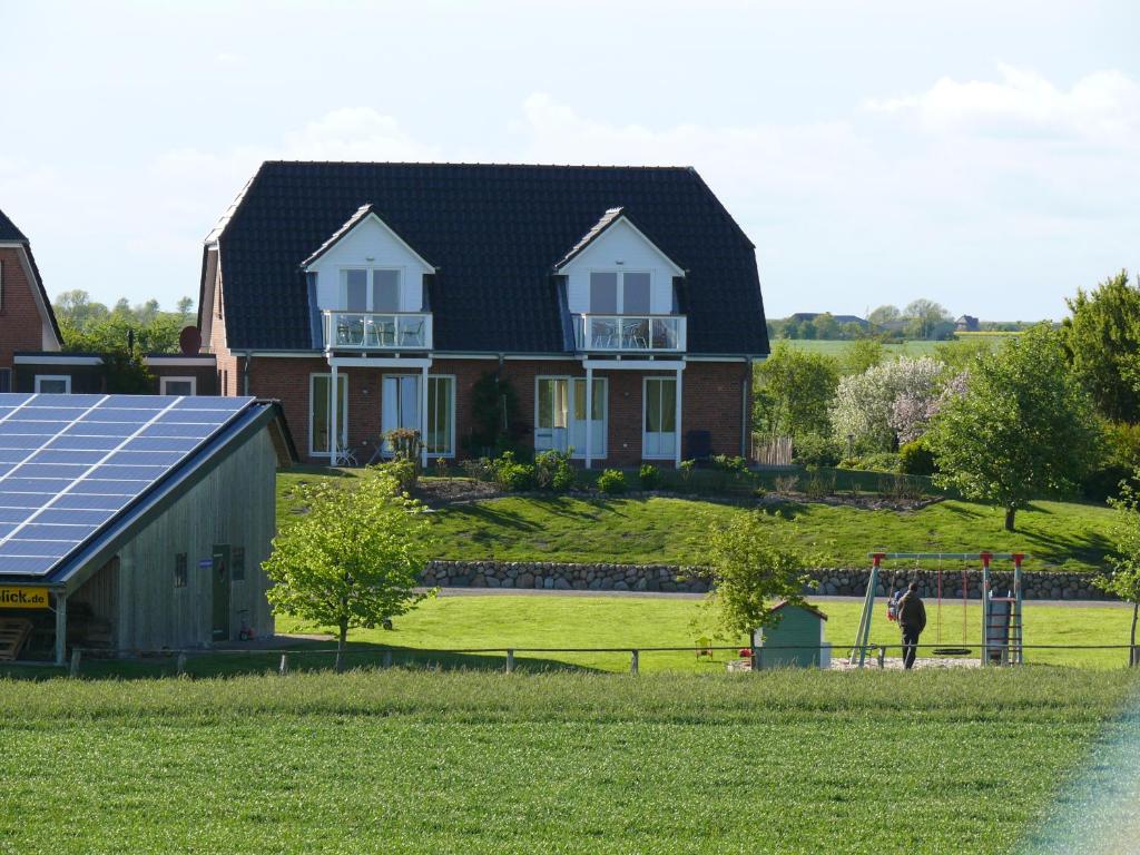 a house with a solar panel on the lawn at Ferienhaus Wattenmeerblick in Nordstrand