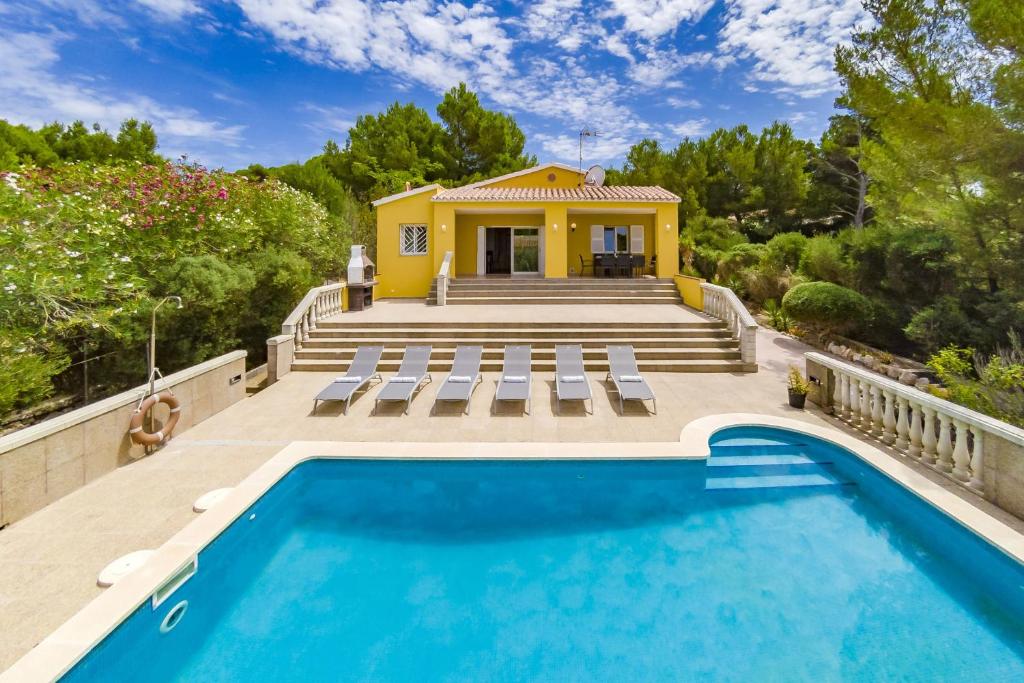 a house with a swimming pool and a yellow house at Villa Novas Park in Son Parc
