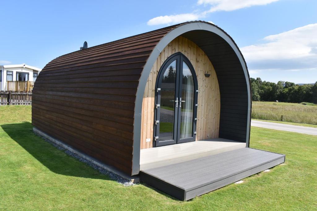 ein kleines rundes Gebäude mit einem großen Fenster in der Unterkunft Grantown Caravan Park in Grantown on Spey