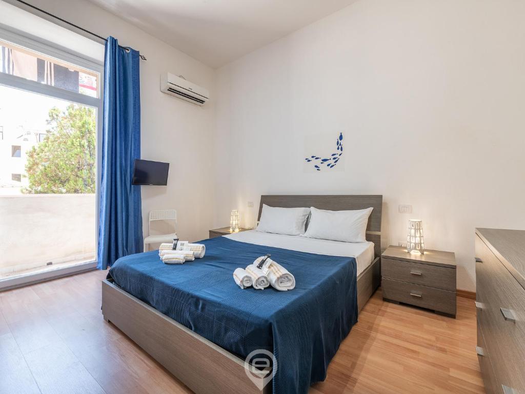 - une chambre avec un lit et une grande fenêtre dans l'établissement Villanova Rooms, à Cagliari