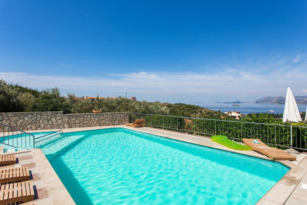 a swimming pool with a view of the ocean at Apartments Bell Memories in Cavtat