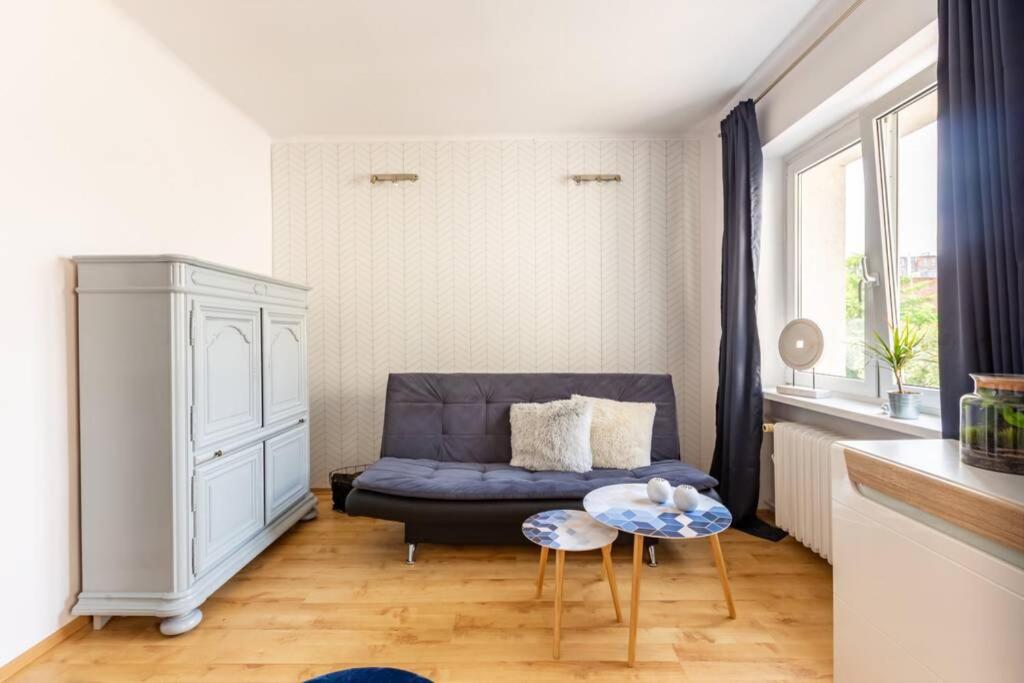 salon z niebieską kanapą i stołem w obiekcie Apartament - Nowoczesny i Stylowy w Bydgoszczy