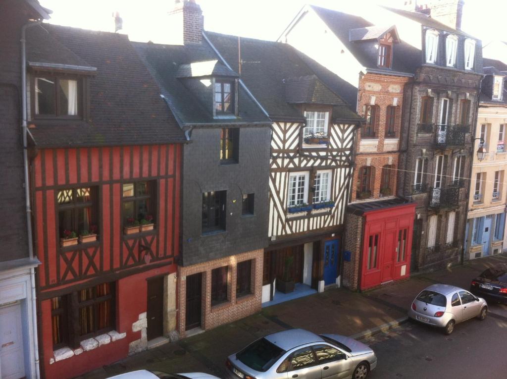 un grupo de edificios con coches estacionados en una calle en Les Charmettes, en Honfleur