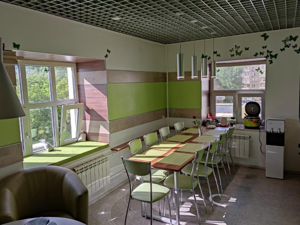 a restaurant with green walls and tables and chairs at City Garden Hotel Taganskaya in Moscow
